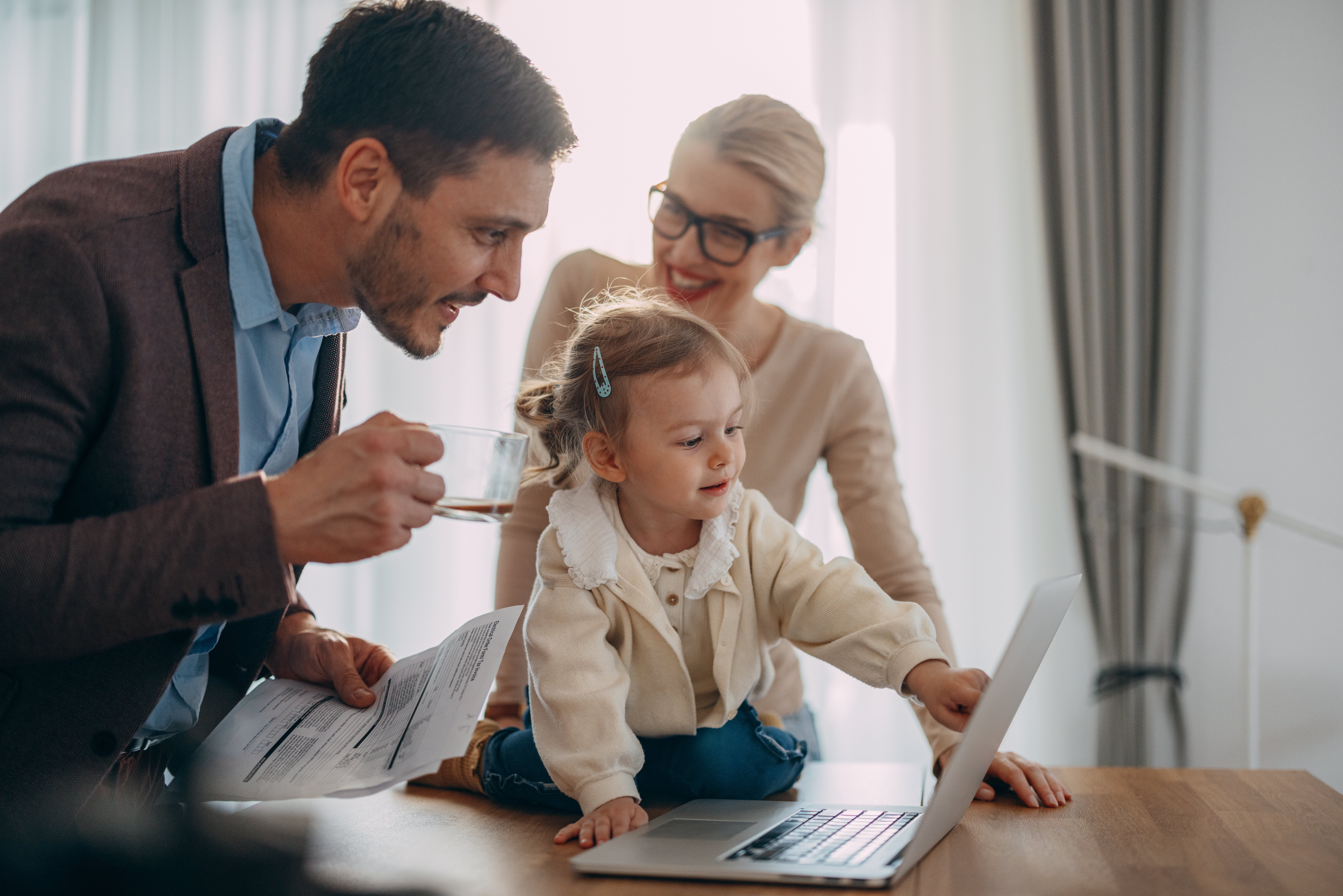 Portrait of a Cute Girl Using Laptop While Her Parents Are Discussing a Monthly Bill
