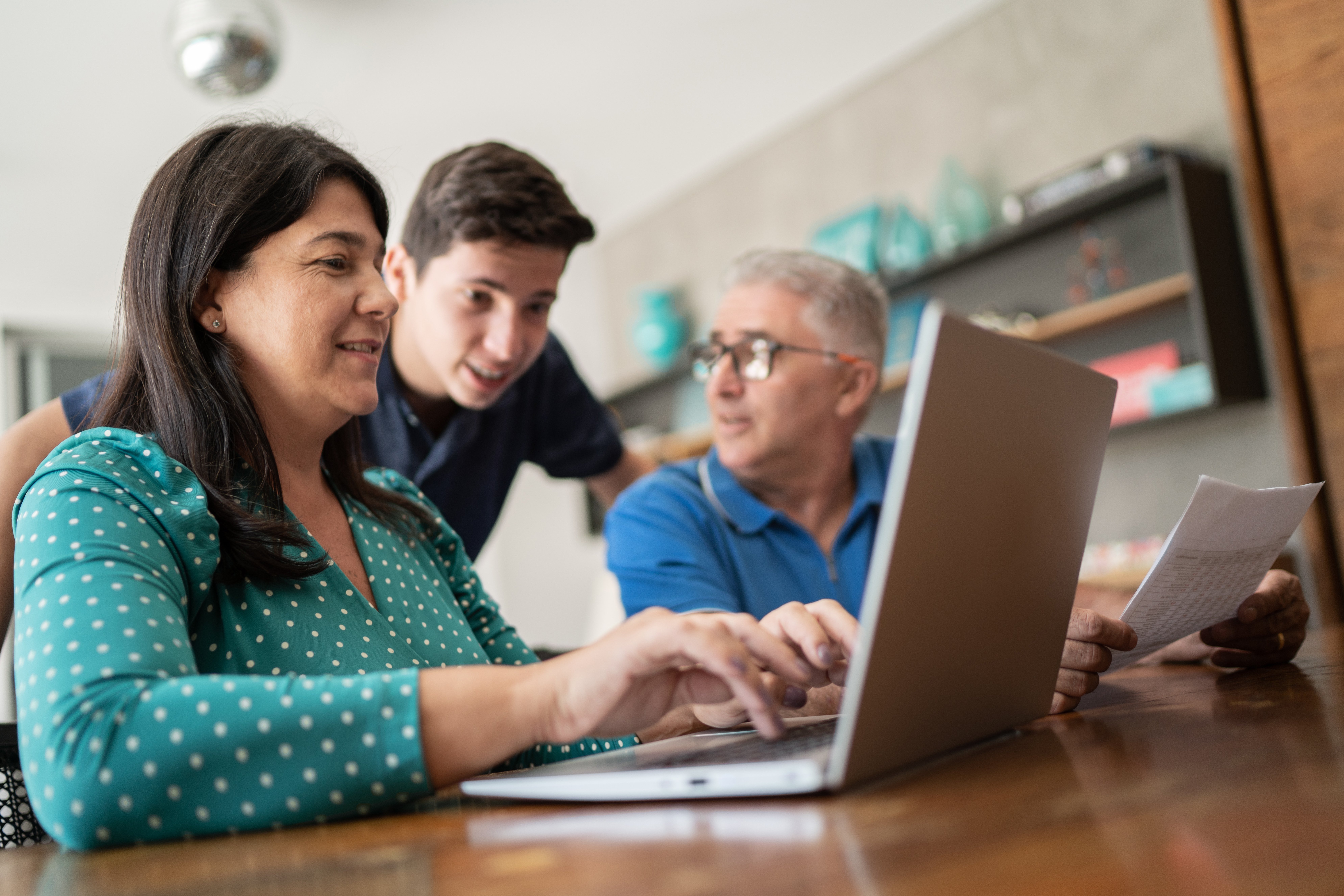 Family filing taxes at a computer together.
