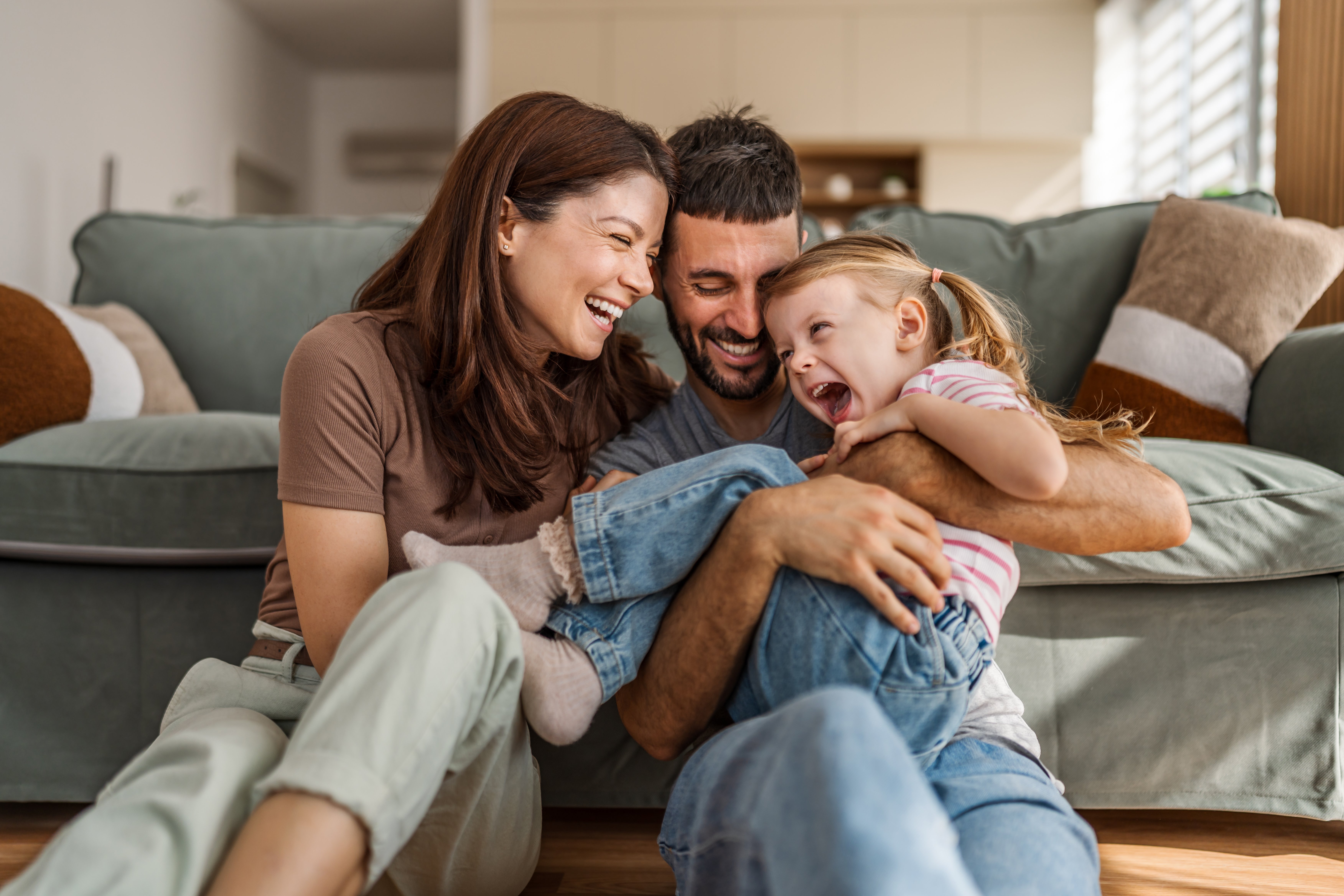Growing family sitting together laughing.